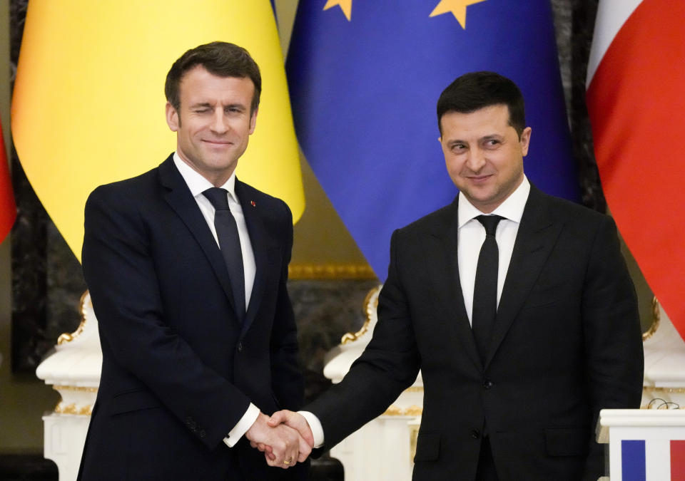 FILE - French President Emmanuel Macron, left, winks as he shakes hands with Ukrainian President Volodymyr Zelenskyy after a joint news conference following their talks in Kyiv, Ukraine, Tuesday, Feb. 8, 2022. France is thousands of miles from Ukraine, but what happens in French voting stations this month could have repercussions in Ukrainian battlefields. Nationalist candidate Marine Le Pen wants to halt arms supplies to Ukraine, improve Western ties with Russia and weaken the EU and NATO, which would undermine long-held Western alliances and efforts to stop the war. (AP Photo/Efrem Lukatsky, File)