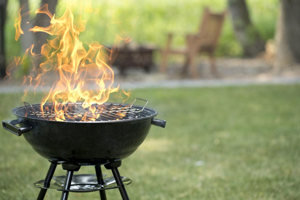 Barbecue grill in backyard with open flame