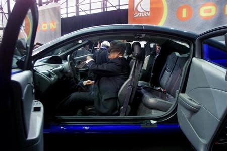 A man sits behind the wheel of the new 2003 Saturn ION quad coupe at its debut at the New York International Auto Show March 27, 2002. REUTERS/Peter Morgan