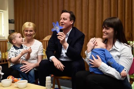 Britain's Prime Minister David Cameron speaks with parents at a nursery during a campaign visit to Cannock, central England, Britain May 6, 2015. REUTERS/Toby Melville