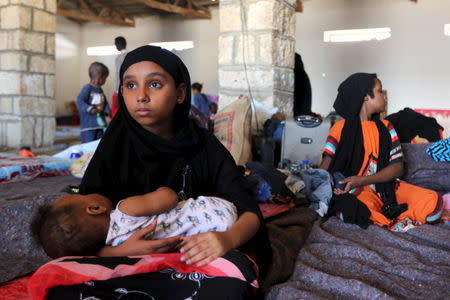 A Yemeni girl holds a baby in a temporary shelter after fleeing violence in Yemen, at the port town Bosasso in Somalia's Puntland April 17, 2015. REUTERS/Feisal Omar