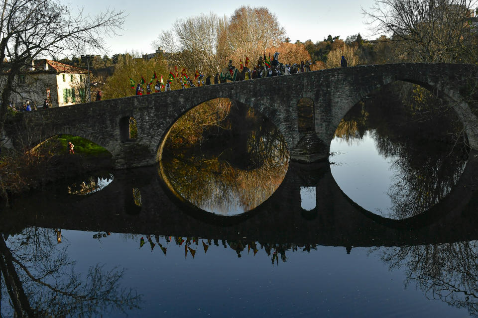 FILE - Three kings of The Cabalgata Los Reyes Magos (Cavalcade of the three kings) are reflected in the waters of the Arga River as they cross the ancient Magdalena bridge before to entrance in the old city during the cavalcade the day before Epiphany, in Pamplona, northern Spain, Thursday, Jan. 5, 2023. The parade symbolizes the coming of the Magi to Bethlehem following the birth of Jesus, marked in Spain and many Latin American countries Epiphany is the day when gifts are exchanged. (AP Photo/Alvaro Barrientos, File)