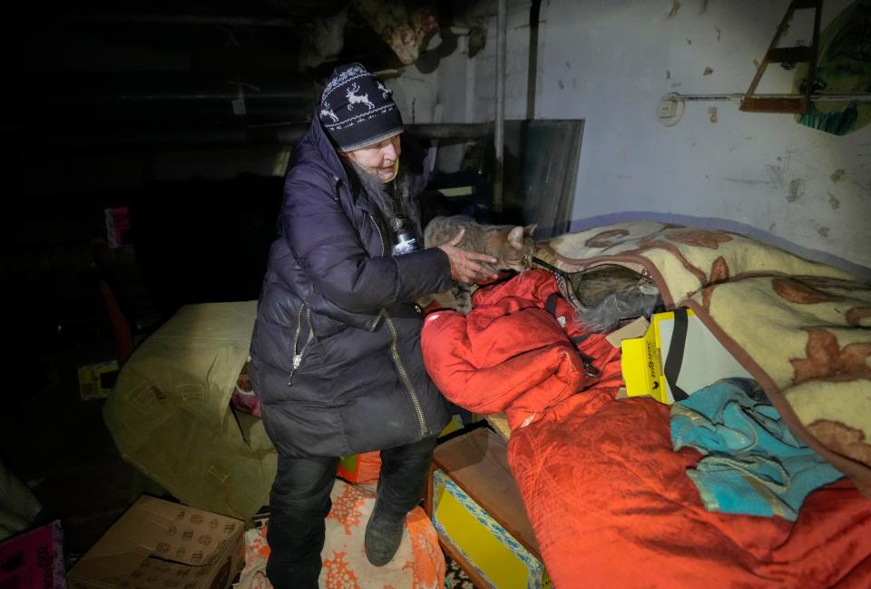 Natalia, 72, saves abandoned cats in a multi-storey house basement that she uses as a bomb shelter hiding from the Russian shelling in Kharkiv (AP)