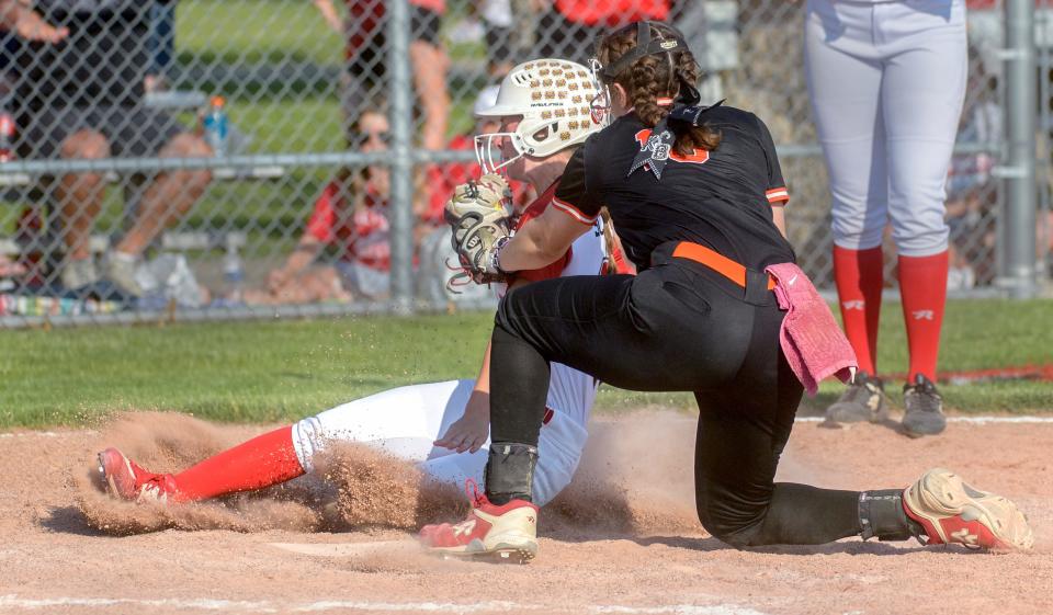 Metamora's Ellie Schaffer slides into home plate as Washington's Brooklyn Ogden tries to tag her out on a wild pitch in the sixth inning of their Class 3A softball sectional title game Friday, June 2, 2023 in Metamora. Schaffer was called safe on the play and the Redbirds went on to win 3-1.