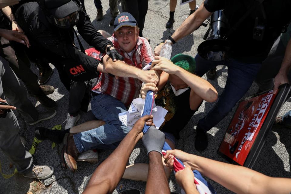 <div class="inline-image__caption"><p>People tussle over a Confederate flag.</p></div> <div class="inline-image__credit">Dustin Chambers/Reuters</div>