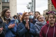 Young people applaud attending the opposition rally in support of jailed opposition leader Alexei Navalny in Moscow, Russia, Wednesday, April 21, 2021. Police across Russia have detained large numbers of people in connection with demonstrations in support of imprisoned opposition leader Alexei Navalny, according to a human rights group. (AP Photo/Alexander Zemlianichenko)