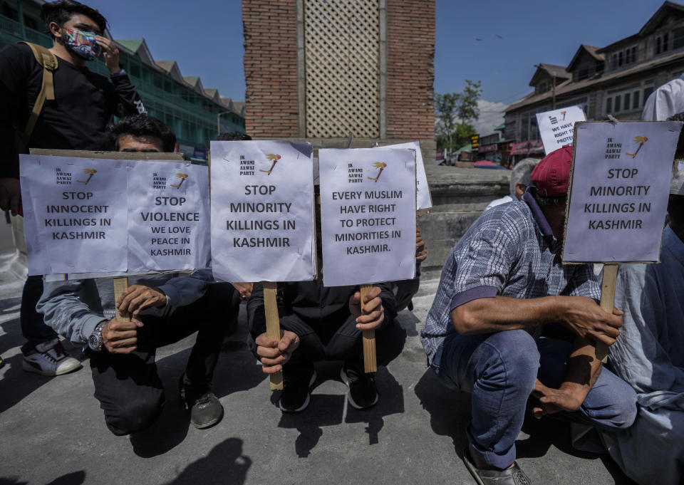 Members of JK Awami Aawaz Party hold placards as they take part in a protest against minority killings, in Srinagar, Indian controlled Kashmir, Thursday, June 2, 2022. Assailants fatally shot a Hindu bank manager in Indian-controlled Kashmir on Thursday, said police, who blamed militants fighting against Indian rule for the attack. (AP Photo/Mukhtar Khan)