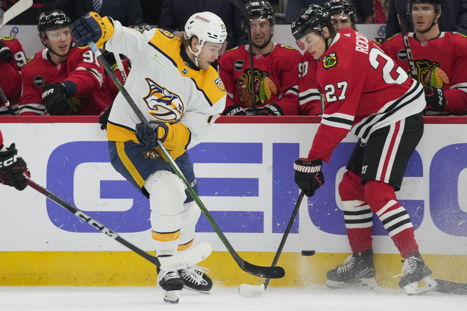 Nashville Predators center Mark Jankowski, left, and Chicago Blackhawks left wing Lukas Reichel fight for control of the puck during the first period an NHL hockey game Tuesday, Dec. 5, 2023, in Chicago. (AP Photo/Erin Hooley)
