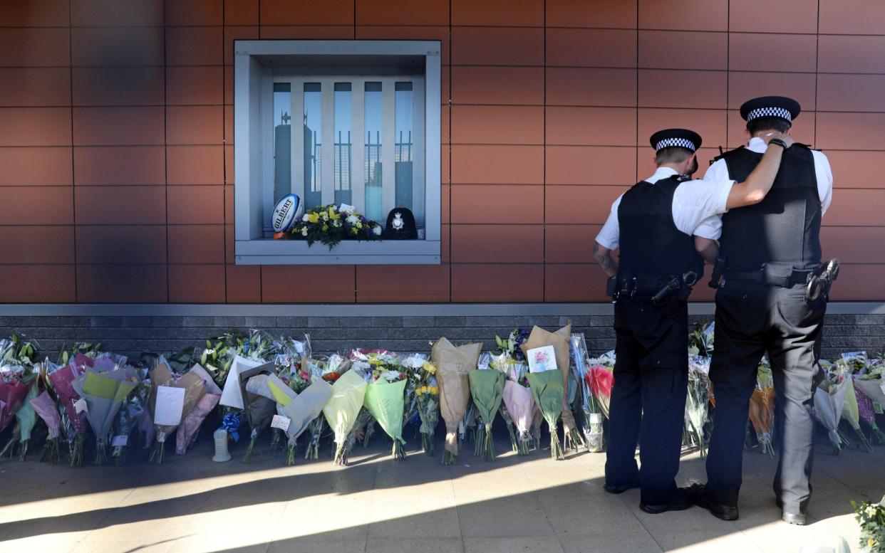 Police officers are seen at the custody centre where a British police officer has been shot dead in Croydon, south London - REUTERS