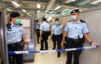 Hong Kong police officers set up police cordon as they search Apple Daily office in Hong Kong