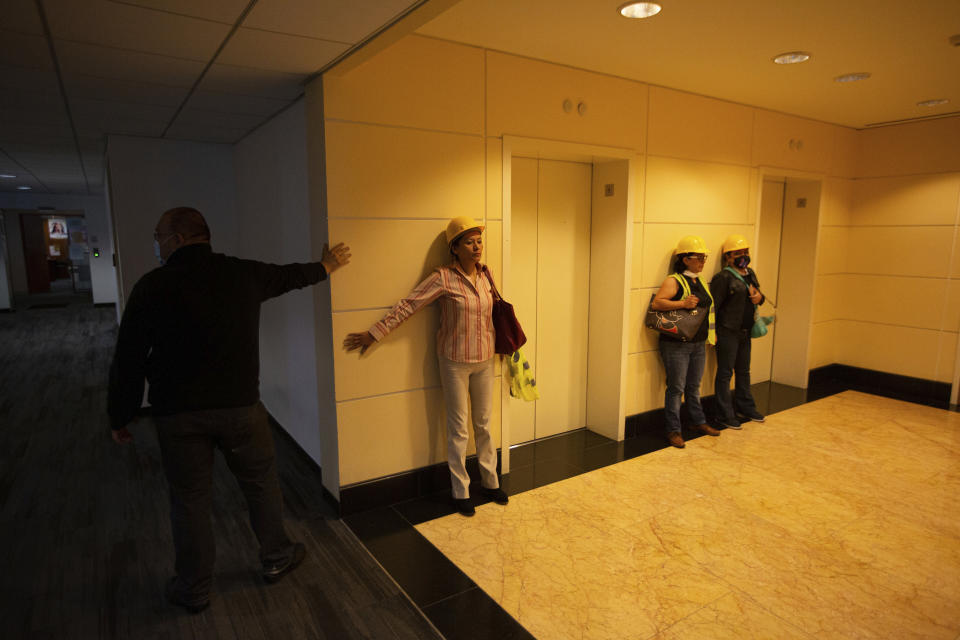 People brace themselves against a wall during a tremor in Mexico City, on Tuesday, June 23, 2020. A magnitude 7.4 earthquake, which centered near the resort of Huatulco in southern Mexico, swayed buildings in the capital and sent thousands into the streets. (AP Photo/Fernando Llano)