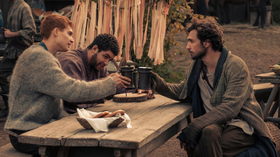 Three boys in The Wheel of Time toast each other