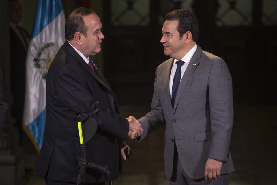 Guatemala's President-elect Alejandro Giammattei, left, and outgoing President Jimmy Morales, shakes hands after a meeting at the National Palace in Guatemala City, Wednesday, Aug. 14, 2019. Giammattei, who takes office Jan. 14 for a four-year term, received nearly 58% of the votes compared in Sunday's presidential runoff. (AP Photo/Moises Castillo)