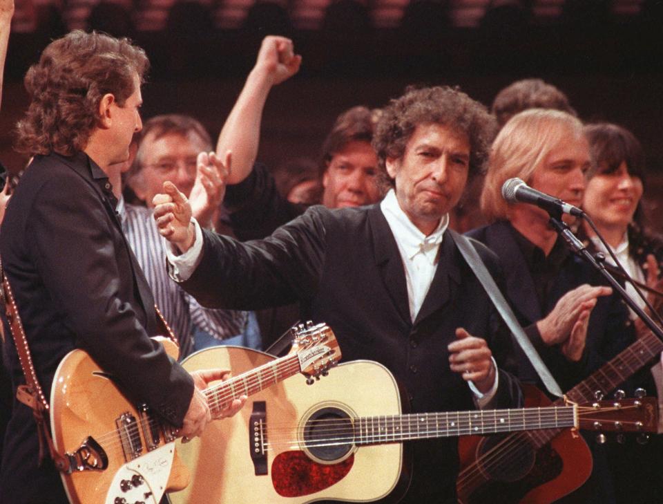 Bob Dylan is joined by other artists after a concert at New York's Madison Square Garden in this Oct. 17, 1992 file photo.  Dylan was hospitalized with a potentially fatal chest infection that forced him to cancel a European tour, the singer s record label said Wednesday, May 28, 1997. Flanking Dylan onstage are Roger McGuinn, left,  and Tom Petty.