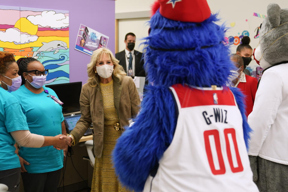 First lady Jill Biden greets medical professionals and Washington Wizards mascot G-Wiz as she arrives to visit with recently vaccinated children at a pediatric COVID-19 vaccination clinic at Children's National Hospital's THEARC, Wednesday, Nov. 17, 2021, in Washington. (AP Photo/Patrick Semansky)