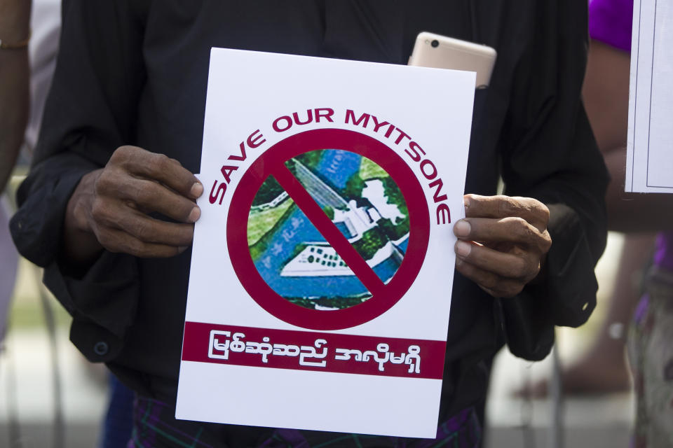 FILE - An activist holds a placard during a protest against Myitsone dam project on the Irrawaddy River in Kachin State, in front of city hall in Yangon, Myanmar Saturday, Jan. 18, 2019. Myanmar's military government appears to be reviving consideration of a massive China-backed hydroelectric dam project, work on which was suspended more than a decade ago after protests over its possible impact on the environment. (AP Photo/Thein Zaw, File)