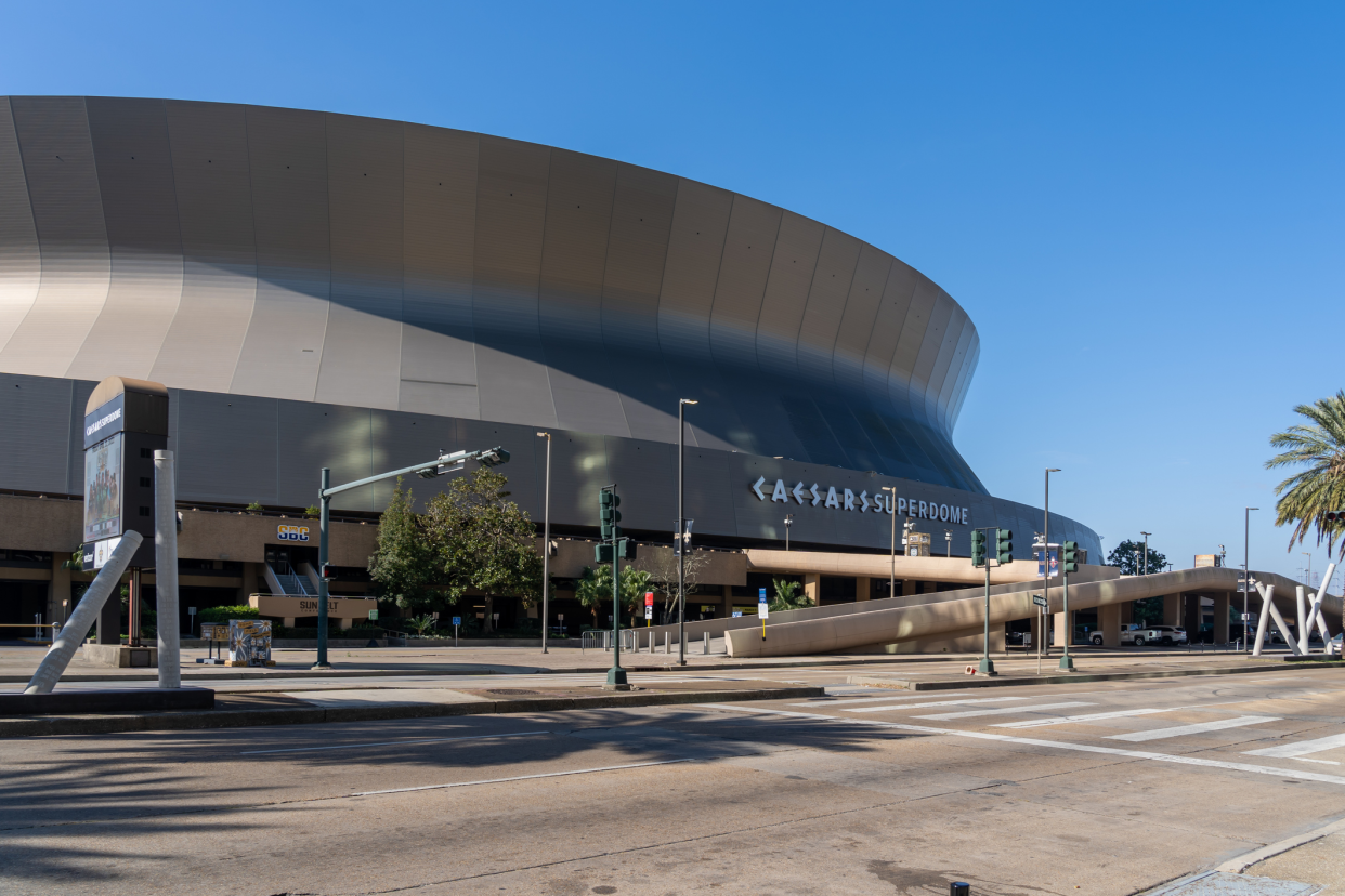 New Orleans Saints, Caesars Superdome, New Orleans, front exterior with road in the foreground against a blue sky