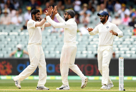 India's Jasprit Bumrah (L) celebrates with captain Virat Kohli after dismissing Australia's captain Tim Paine on day five of the first test match between Australia and India at the Adelaide Oval in Adelaide, Australia, December 10, 2018. AAP/Dave Hunt/via REUTERS