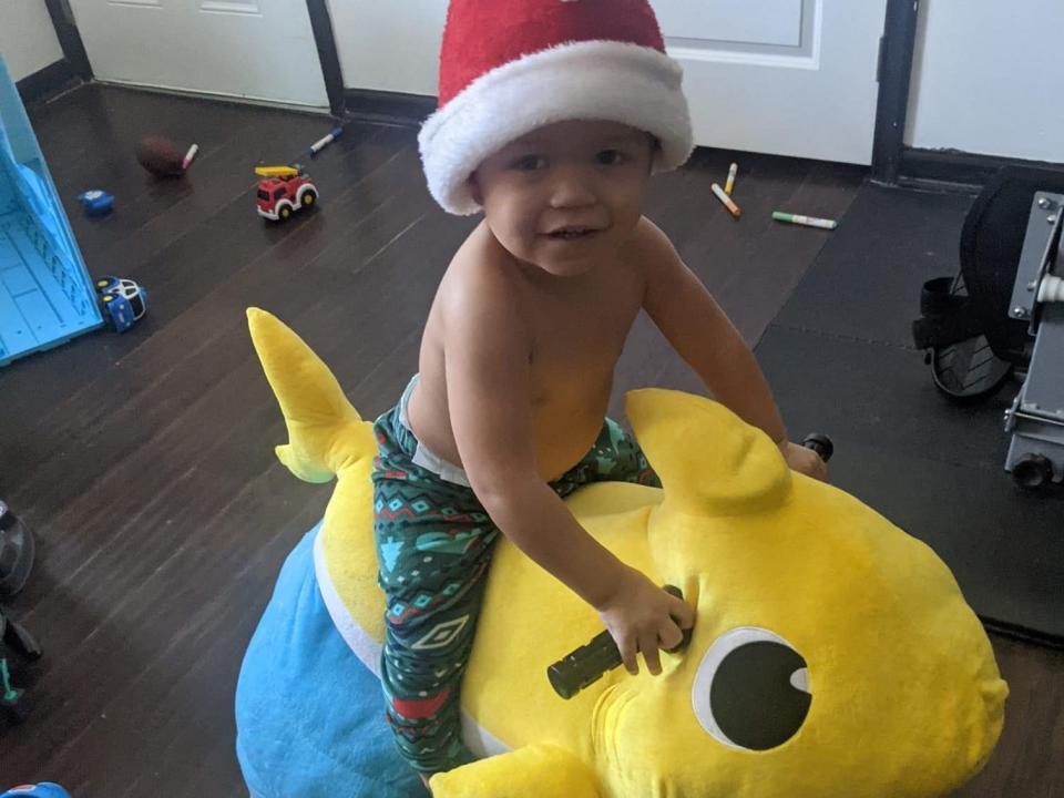 A boy on a "Baby Shark" toy