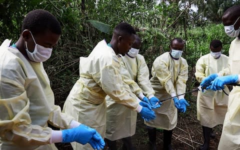 Health workers being disinfected as they undertake the burial of an eleven-month old child in Beni, North Kivu province - Credit: HUGH KINSELLA CUNNINGHAM/EPA-EFE/REX