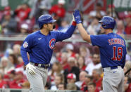 Chicago Cubs' Seiya Suzuki, left, celebrates with teammate Frank Schwindel after scoring against the Cincinnati Reds during the first inning of a baseball game in Cincinnati, Monday, May 23, 2022. (AP Photo/Paul Vernon)