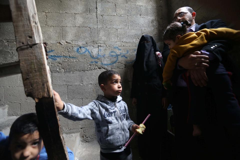 In this Tuesday, March 11, 2014 photo, Ahmed Zeitouniya, 32, an employee of the Culture Ministry, holding his daughter Mariam, his wife Minatullah, 29, their other children Hani, 5, Mohammed, 4, are seen at their family house in Gaza City in the northern Gaza Strip. Gaza's Hamas rulers have been hit by the worst economic crisis since seizing the territory seven years ago and face growing discontent, even among core supporters, because there's no sign of relief from a blockade enforced not only by Israel but also by a suddenly hostile Egypt. (AP Photo/Hatem Moussa)