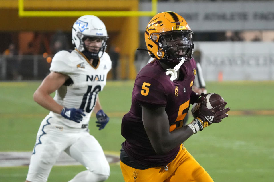 Arizona State defensive back Chris Edmonds (5) runs past Northern Arizona wide receiver Hendrix Johnson after intercepting a pass during the second half of an NCAA college football game Thursday, Sept. 1, 2022, in Tempe, Ariz. (AP Photo/Rick Scuteri)