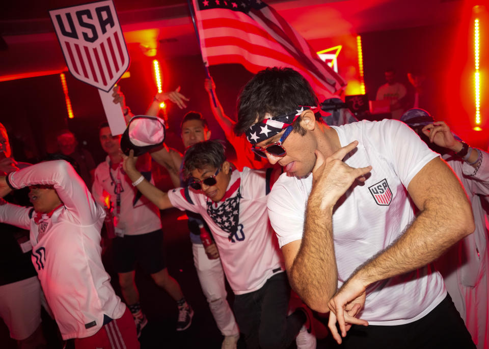 People dance during an official U.S. Soccer fan party at the Budweiser World Club ahead of a FIFA World Cup group B soccer match between the United States and Wales, in Doha, Sunday, Nov. 20, 2022. (AP Photo/Ashley Landis)