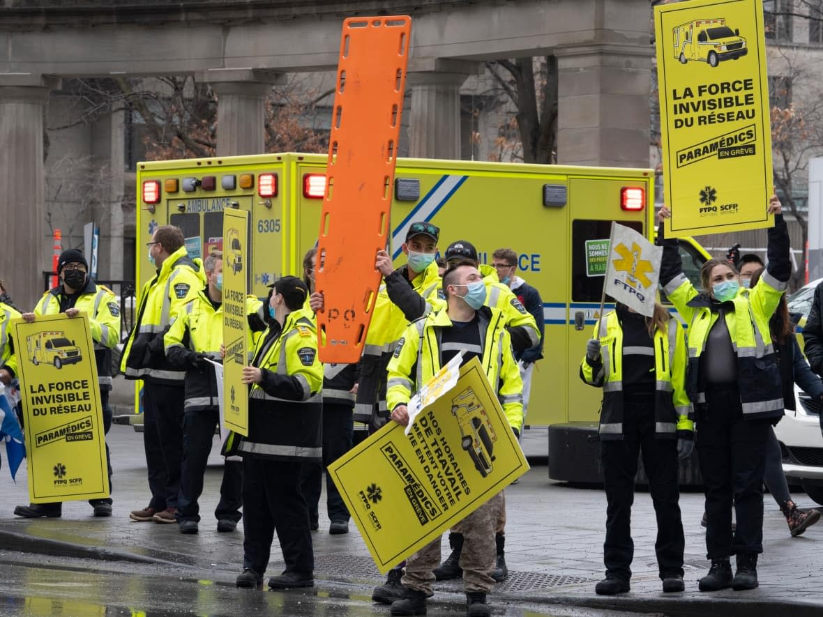 Paramedics protest their working conditions outside the premier's office in March. They hold signs saying they are the invisible strength of the health-care system. (Ryan Remiorz/The Canadian Press - image credit)