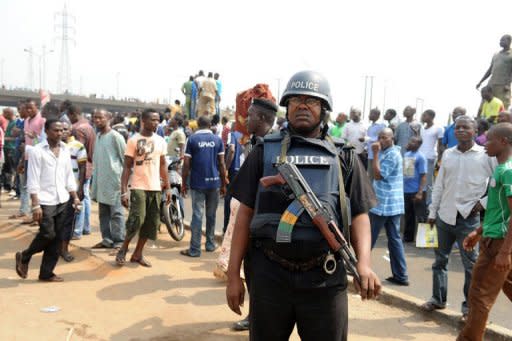 A policeman stands watching thousands of protesters gather at Gani Fawehinmi Park to protest. A Nigerian oil workers union threatened to shut down crude production in Africa's largest oil producer as a nationwide strike over soaring fuel prices pushed on for a third day