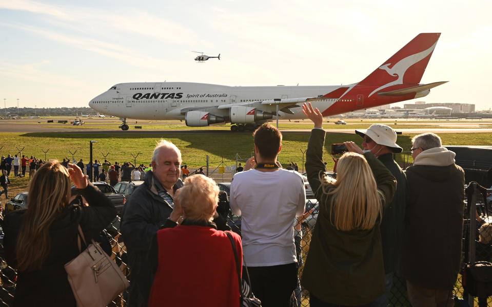 People watch as the last Qantas Boeing 747 airliner prepares to take off from Sydney airport to the US on July 22, 2020. The downturn in the airline industry following travel restrictions imposed by the COVID-19 outbreak forced Qantas to retire its grounded 747s after flying with the Australian carrier for almost 50 years.<span class="copyright">Peter Parks—AFP/Getty Images</span>