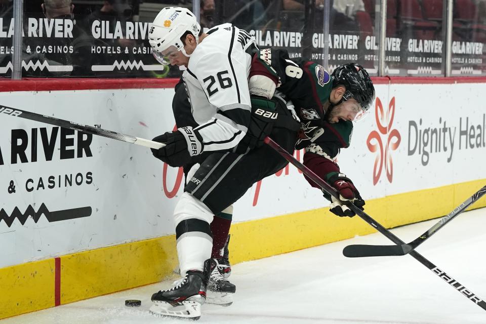 Los Angeles Kings defenseman Sean Walker (26) battles with Arizona Coyotes center Derick Brassard (16) for the puck during the first period of an NHL hockey game Monday, May 3, 2021, in Glendale, Ariz. (AP Photo/Ross D. Franklin)