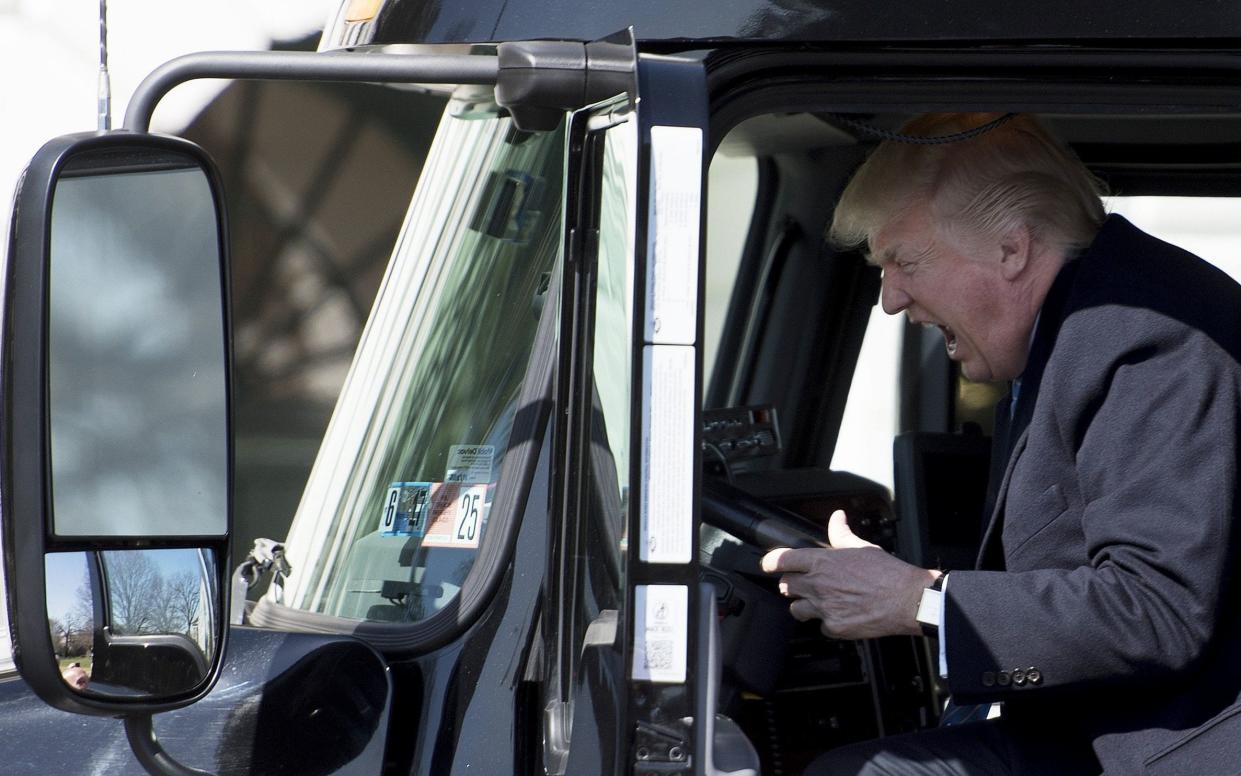 US President Donald Trump sits in the drivers seat of a semi-truck as he welcomes truckers and CEOs to the White House in Washington - AFP