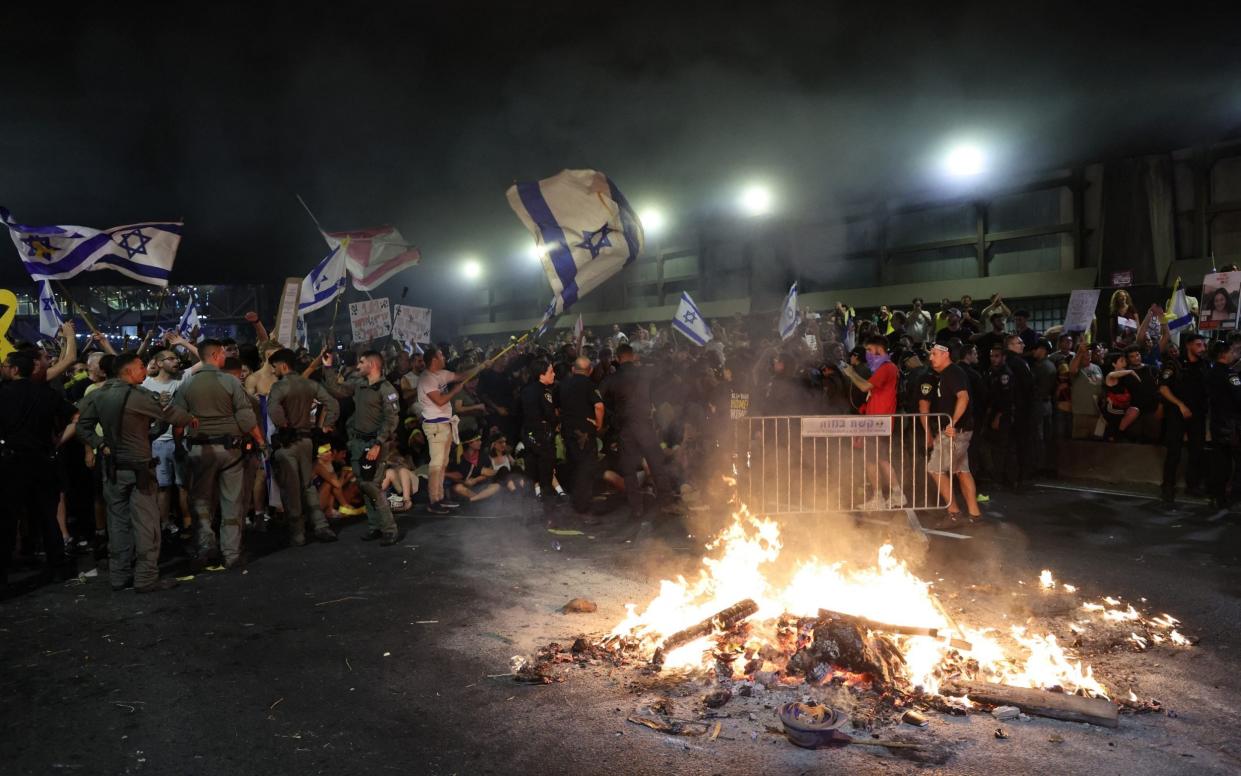 Israeli police officers face protesters during an anti-government rally calling for the release of Israelis held hostage