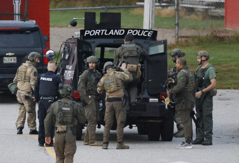 Lisbon, ME - October 26: Law enforcement officials load into a tactical vehicle at Lisbon High School at daybreak as a manhunt resumes for the suspect in a mass shooting that took place the day prior. (Photo by Jessica Rinaldi/The Boston Globe via Getty Images)