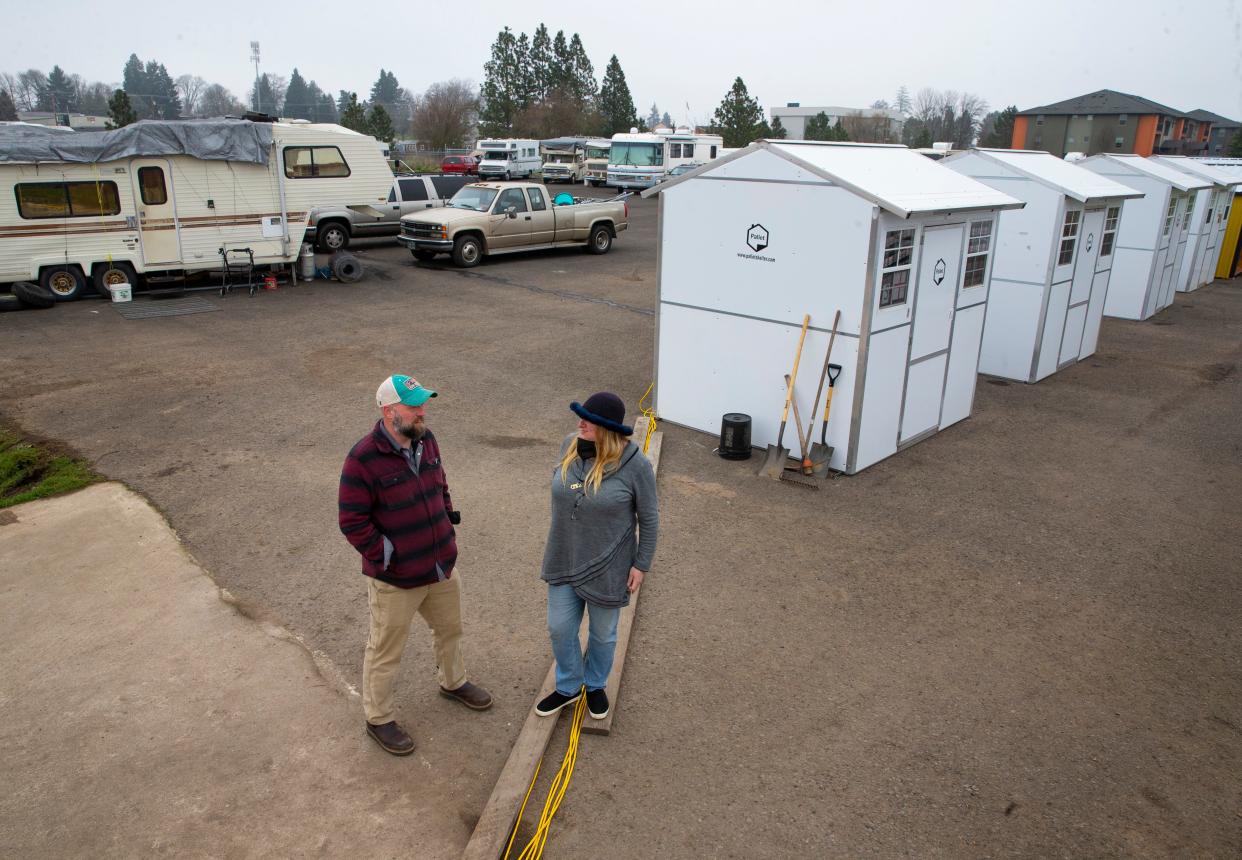 Co-founders of Everyone Village Gabe Piechowicz, left, and Heather Sielicki stand on the site of the new Safe Sleep site in west Eugene.