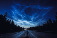 <p>Noctilucent clouds stretch across the Swedish sky illuminating a motorcyclist’s ride home in this dramatic display. (Pic: Ruslan Merzlyakov) </p>