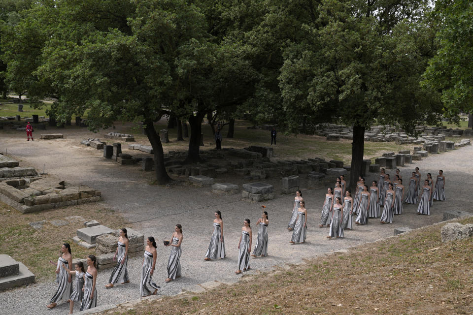 Performers take part in the official ceremony of the flame lighting for the Paris Olympics, at the Ancient Olympia site, Greece, Tuesday, April 16, 2024. The flame will be carried through Greece for 11 days before being handed over to Paris organizers on April 26. (AP Photo/Thanassis Stavrakis)