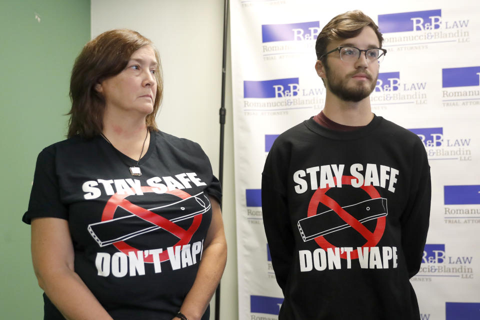 Adam Hergenreder, right, and his mother Polly, attend a news conference where their attorney announced the filing of a civil lawsuit against e-cigarette maker Juul on Hergenreder's behalf Friday, Sept. 13, 2019, in Chicago. The lawsuit filed Friday in Lake County, Illinois, Circuit Court alleges Juul Labs, Inc., deliberately targeted young people through Instagram and other sites to suggest vaping can boost their social status. It also says Juul doesn't fully disclose their products contain dangerous chemicals. (AP Photo/Charles Rex Arbogast)
