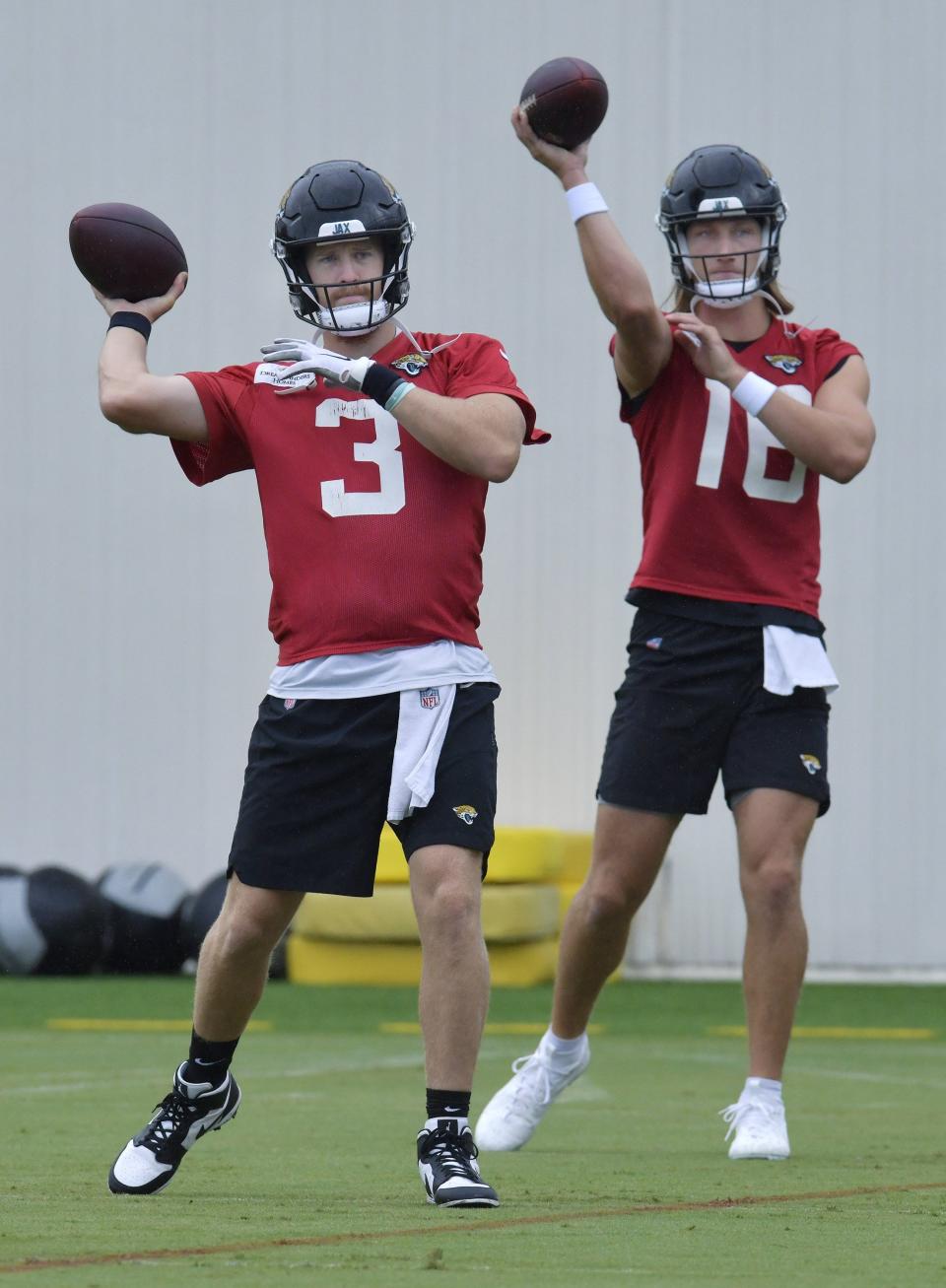 Jacksonville Jaguars quarterbacks C.J. Beathard (3) and Trevor Lawrence (16) work on passing techniques during Friday's training camp session at the Miller Electric Center.