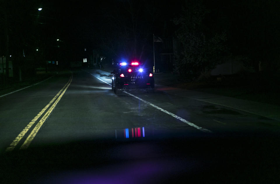 Police car with flashing lights parked on a nighttime street