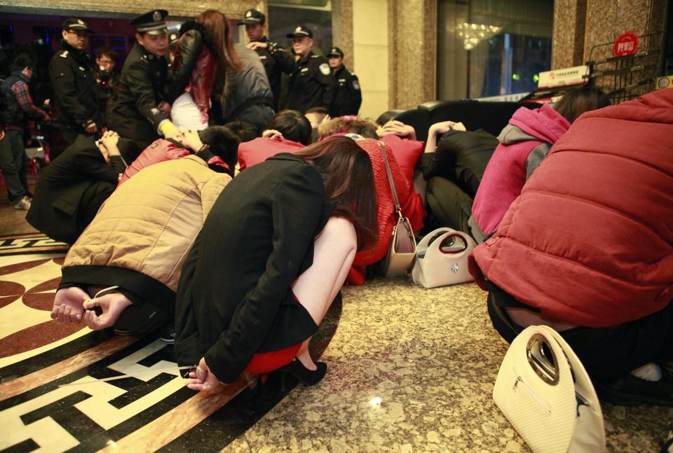 Police conduct a head count of suspects who were detained during a police raid, as part of plans to crackdown on prostitution, at a hotel in Dongguan, Guangdong province, February 9, 2014. Chinese authorities have carried out a rare crackdown on the sex trade in the "sin city" of Dongguan following a candid report by the state broadcaster on the underground industry. Picture taken February 9, 2014. REUTERS/Stringer (CHINA - Tags: CRIME LAW) CHINA OUT. NO COMMERCIAL OR EDITORIAL SALES IN CHINA