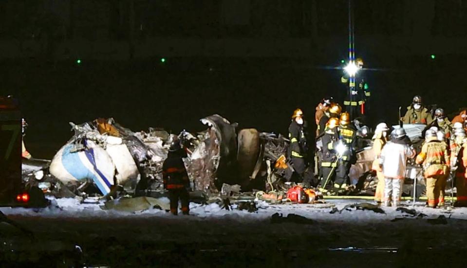 Firefighters near the wreckage of the Japan Airlines jet (AP)