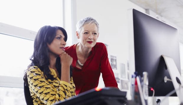 Mature business woman mentoring younger employee.