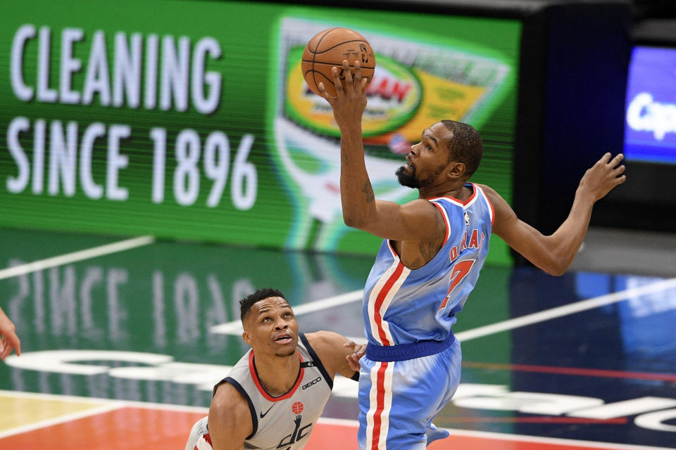 Brooklyn Nets forward Kevin Durant, right, controls the ball against Washington Wizards guard Russell Westbrook, left, during the first half of an NBA basketball game, Sunday, Jan. 31, 2021, in Washington. (AP Photo/Nick Wass)