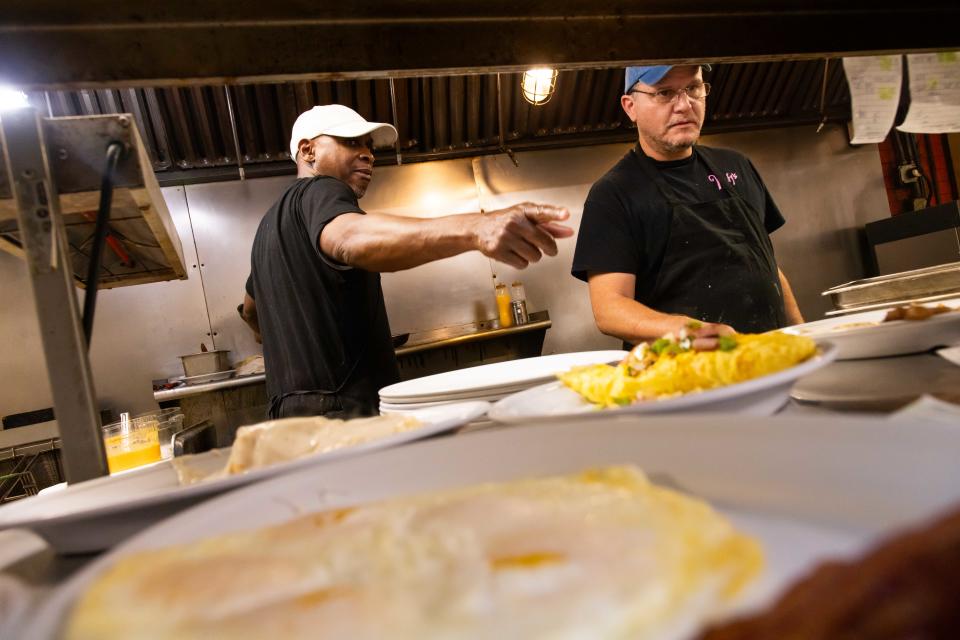 Wolfy’s cooks Regi Harris, left, and Carlos Sanchez, right, fill breakfast orders on Jan. 30.