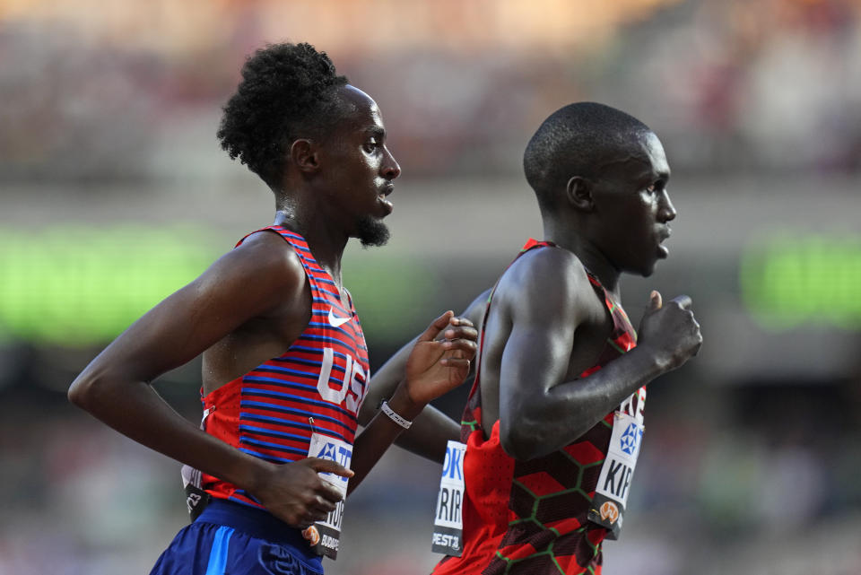 Abdihamid Nur, of the United States, left, and Nicholas Kipkorir, of Kenya compete in a Men's 5000-meters heat during the World Athletics Championships in Budapest, Hungary, Thursday, Aug. 24, 2023. (AP Photo/Petr David Josek)