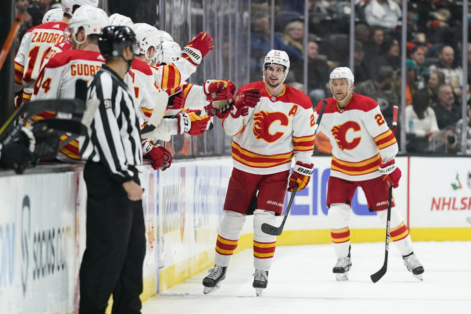 Calgary Flames' Sean Monahan, center, celebrates his goal during the second period of an NHL hockey game against the Anaheim Ducks, Friday, Dec. 3, 2021, in Anaheim, Calif. (AP Photo/Jae C. Hong)