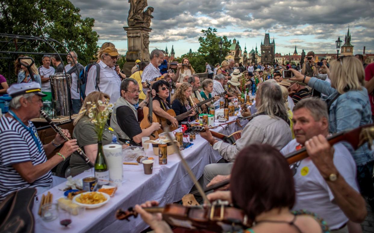 Musicians perform as diners sit at a gigantic table spanning Prague's Charles Bridge  -  MARTIN DIVISEK/EPA-EFE/Shutterstock