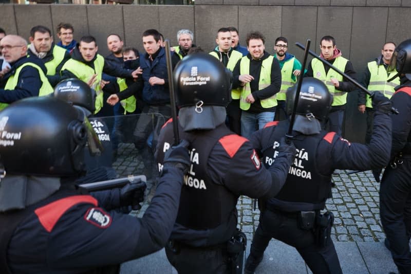 People confront the Navarra Foral Police during Farmers' protest at the back of the Parliament of Navarra, after trying to enter the Parliament while the General Budgets of Navarra for 2024 were being debated. Eduardo Sanz/EUROPA PRESS/dpa